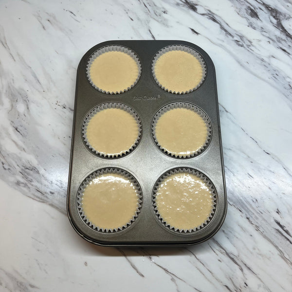 adding the mochi muffin batter to the muffin tin